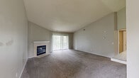 Located at 2651 Greenstone Blvd in Auburn Hills, Michigan, this well-designed 2-bedroom, 2-bathroom residence offers a comfortable and functional single-floor layout. The open-concept living and dining area serves as the heart of the home, featuring plush carpeting, a textured ceiling, and a tile-surround fireplace with a white mantle. A sliding glass door floods the space with natural light and provides outdoor views, creating a bright and welcoming atmosphere. Vaulted ceilings in the dining area add a sense of airiness, and a pass-through window connects seamlessly to the kitchen. The kitchen is equipped with rich, dark wood cabinetry, light stone-look countertops, wood-look flooring, and stainless steel appliances including a dishwasher. The spacious primary bedroom offers generous room for furnishings and includes access to ample closet space. The second bedroom is equally well-sized with soft carpeting and neutral tones. Both bathrooms feature wood-look tile flooring, dark wood vanities with white countertops, and clean, modern fixtures. Additional highlights include four closets for abundant storage, a dedicated laundry area, and hallways connecting the home's layout efficiently. The overall aesthetic is clean, neutral, and move-in ready.