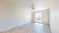 This contemporary apartment in San Diego offers 620 square feet of thoughtfully designed living space. The open-concept layout maximizes the area, seamlessly blending the living room and kitchen. Large windows flood the interior with natural light and provide panoramic city views, enhancing the sense of space.

The kitchen boasts modern white cabinetry, stainless steel appliances, and a functional island, perfect for casual dining or meal preparation. Light wood-tone flooring throughout adds warmth and continuity to the space.

The primary bedroom, measuring 130 square feet, features a large window and plush carpeting for comfort. The second bedroom, while compact, offers versatility as a guest room or home office. The bathroom showcases a sleek design with a glass-enclosed shower, modern fixtures, and ample storage.

High ceilings and recessed lighting contribute to the apartment's airy ambiance. A ceiling fan in the main living area provides both style and functionality. The unit also includes a closet for additional storage.

This apartment combines efficient space utilization with contemporary design, creating an ideal urban living environment in the heart of San Diego.