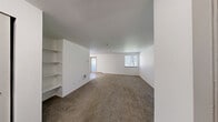 Located at Briarstone in Tacoma, WA, this single-floor residence offers three bedrooms, two bathrooms, a kitchen, living room, hallway, and two closets. The expansive living room features neutral carpet flooring, crisp white walls, a textured ceiling, built-in shelving, and multiple windows that invite natural light and views of surrounding greenery. A sliding door provides additional access and brightness to the space. The kitchen is appointed with light wood-style flooring, a peninsula with a speckled countertop, ample cream cabinetry, a white electric range, a refrigerator, a stainless steel sink, and a window above the counter. The bedrooms are carpeted with clean white walls and sliding closet doors, with at least one bedroom offering a window with natural light and a baseboard heater. The two bathrooms differ in configuration — one includes a tub/shower combo with wood-style flooring and a vanity with a speckled countertop, while the second features a standalone shower stall with a curtain rod. A hallway connects the rooms efficiently throughout the layout, providing a cohesive and functional flow across the entire residence.