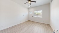 Located at 358 E Roeser Rd in Phoenix, AZ, this single-story unit offers three bedrooms and two bathrooms within a thoughtfully designed, efficiently laid-out floor plan. Light wood-style flooring runs throughout, complementing the clean white walls and creating a bright, cohesive aesthetic across every room.

The open-concept living area flows directly into the kitchen, which is a standout feature of the home. White shaker cabinets with matte black hardware are paired with stone-look countertops, a stainless steel undermount sink, and a full suite of stainless steel appliances including a French door refrigerator, electric range, over-the-range microwave, and dishwasher. A window above the sink allows natural light to fill the space.

Each of the three bedrooms features light wood-style flooring, a ceiling fan, and windows fitted with horizontal blinds that provide outdoor views and natural light. The bedrooms are well-proportioned, offering comfortable, functional spaces.

The two bathrooms are finished in a clean, modern style with white vanities, tiled walk-in showers with glass doors, and matte black fixtures. A dedicated laundry area houses a stacked washer and dryer unit for added convenience.

Recessed lighting and ceiling fans throughout enhance both function and comfort in this move-in ready Phoenix home.