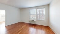 This well-appointed one-bedroom, one-bathroom residence at 103 S Wood Ave in Linden, NJ offers a thoughtfully designed layout across a single floor. Rich hardwood flooring flows throughout the entire unit, lending warmth and continuity to every room. The open-concept kitchen and living area forms the heart of the home, where a sleek granite-topped peninsula with an undermount sink serves as both a functional workspace and a natural gathering point. The kitchen is equipped with dark espresso cabinetry, black appliances including a refrigerator, electric range, and microwave, and is accented by a modern track lighting fixture overhead. The living area benefits from a large window that invites natural light and offers views of the surrounding neighborhood. The bedroom is a comfortable, well-lit retreat featuring a window with blinds and a wall-mounted HVAC unit. A dedicated walk-in closet with wire shelving provides ample storage. The bathroom includes a full soaking tub and shower combination with classic white subway tile surround and light tile flooring. A solid paneled entry door with modern hardware completes this clean, move-in-ready residence.