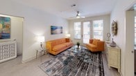 This well-appointed single-floor residence showcases a contemporary design aesthetic throughout, with light wood-style flooring and a neutral color palette that creates a cohesive, modern feel across all rooms. The kitchen is a standout feature, offering two distinct layouts: one with a large center island fitted with pendant lighting and seating, and another with clean-lined two-tone cabinetry in white and dark gray. Both configurations include stainless steel appliances, white quartz countertops, and a stylish tile backsplash, making the kitchen both functional and visually striking. The open-concept layout connects the kitchen seamlessly to the living area, which is bathed in natural light from large windows and a glass-panel door leading to a private balcony. A ceiling fan adds comfort and a practical touch to the living space. The primary bedroom is generously sized, featuring dual windows that allow ample natural light, and is accompanied by a full bathroom with a long wood-toned vanity, walk-in shower with curtain, and direct access to a spacious walk-in closet with wire shelving. A second bedroom mirrors the bright, comfortable feel. The secondary bathroom offers a clean, all-white design with a soaking tub and shower combo, a wood-grain vanity, and a mirrored medicine cabinet.