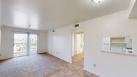 Located at 1745 E Fairway Dr in Orange, CA, this single-floor, two-bedroom, one-bathroom unit offers a practical and well-organized layout. The open living and entry area features a combination of neutral carpet and tile flooring, with bright white walls throughout that reflect natural light and create a clean, airy atmosphere. Ceiling-mounted light fixtures and wall vents indicate a central HVAC system for year-round comfort.

The kitchen is efficiently designed with white cabinetry extending to the ceiling for ample storage, a white gas range, a full-size refrigerator, and tile flooring — all arranged in a compact, functional configuration. Adjacent to the kitchen, a hallway connects the main living area to the bedrooms and bathroom.

The spacious primary bedroom is generously sized and features wall-to-wall carpeting, vertical blinds, and a sliding glass door that opens onto a private balcony with views of surrounding palm trees and the neighborhood. The second bedroom is also carpeted, with a window that lets in natural light and a neutral, versatile layout.

The bathroom is clean and straightforward, featuring tile flooring, a white vanity with mirror, and standard fixtures. Overall, this unit offers a functional, well-lit living space in a convenient Southern California location.