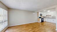 Located at 744 N Azusa Ave in West Covina, CA, this one-bedroom, one-bathroom unit offers a practical and well-appointed single-floor layout. Warm hardwood-style flooring flows consistently throughout the space, creating a cohesive and inviting atmosphere.

The open-concept living and kitchen area forms the heart of the unit. The living room is bright and airy, featuring large vertical-blind-covered windows that allow natural light to fill the room, along with a wall-mounted air conditioning unit. The kitchen is well-equipped with crisp white shaker-style cabinetry, granite-look countertops, a stainless steel sink, and black appliances including a range and over-the-range microwave — offering ample storage and counter space for everyday cooking.

The bedroom is a comfortable, well-sized retreat featuring a ceiling fan with light fixture, a window with natural light, and access to a dedicated closet with built-in shelving. A vanity area is conveniently integrated just outside the bathroom.

The bathroom is clean and functional, featuring a tub/shower combination with elegant marble-style tile surround and chrome fixtures.

Textured ceilings are present throughout, and the neutral wall tones create a versatile backdrop throughout the entire unit.