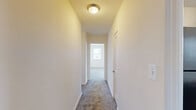 Located in Towson, MD, this single-floor residence offers four bedrooms, one bathroom, and a kitchen connected by three hallways. The layout is straightforward and functional, with neutral cream-toned walls and plush carpeting throughout the bedroom areas that create a cohesive, understated aesthetic.

The primary bedroom is the most expansive of the four, featuring three windows that invite abundant natural light and offer pleasant outdoor views of the surrounding greenery. The remaining bedrooms are comfortably sized with carpeted floors and windows that maintain a bright, airy feel throughout.

The kitchen is well-equipped, showcasing rich dark wood cabinetry, light granite-style countertops, hardwood flooring, and black appliances including an electric range with overhead ventilation. A stainless steel sink and dishwasher round out the practical amenities, with a window above the counter providing additional natural light.

The bathroom is finished with classic white subway tile wainscoting, a wood-toned vanity with a white countertop, a mirrored medicine cabinet, and a window that keeps the space feeling open and fresh.

Connecting hallways are carpeted and ceiling-lit, providing smooth transitions between rooms. Overall, the space offers a clean, move-in ready environment with practical finishes throughout.