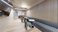 Located at 2020 Kittredge St in Berkeley, CA, this contemporary community lounge and recreation space is thoughtfully designed to encourage social interaction and leisure. The single-floor layout follows a long, open corridor-style plan with light wood flooring throughout, creating a warm and cohesive aesthetic.

A striking slatted wood accent wall runs along one side of the main lounge area, lending a modern, architectural character to the space. Comfortable modular seating — including a long channel-tufted sectional sofa paired with textured boucle chairs and round bistro tables — creates an inviting area for conversation and relaxation. Linear LED lighting suspended from exposed ceilings with visible ductwork and conduit adds an industrial-chic element to the overall design.

The recreation zone features a full-size pool table with a vibrant blue felt surface, a shuffleboard table, and a foosball table, providing ample entertainment options. The pool area is anchored by a dark accent wall adorned with contemporary artwork, along with a wall-mounted flat-screen television and a compact kitchenette equipped with a sink and microwave. Small clerestory windows allow natural light to filter in, complementing the bright, recessed linear lighting. The space also includes additional lounge seating at the far end, completing this versatile and well-appointed communal amenity.