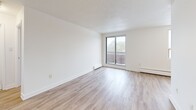 Located on the fourth floor at 40 Vanier Drive in Guelph, Ontario, this one-bedroom, one-bathroom unit offers a well-organized and efficiently designed layout. Light-toned hardwood flooring runs throughout the unit, lending a clean and cohesive look to every room.

The living room is bright and open, featuring large sliding glass doors that lead directly to a private balcony, allowing for generous natural light and outdoor views of the surrounding greenery. An additional window further enhances the airy feel of the space. Baseboard heating runs along the perimeter walls throughout the unit.

Adjacent to the living area, the dining room provides a functional space for everyday meals. The kitchen is thoughtfully appointed with white cabinetry, dark countertops, a subway tile backsplash, stainless steel appliances including a full-size refrigerator, and a stainless steel sink — all contributing to a contemporary and practical cooking environment.

The bedroom is a comfortable, well-proportioned room with a large window overlooking trees, a built-in closet with bifold doors, and the same warm hardwood flooring found throughout. With four closets total across the unit, storage is plentiful.

The bathroom and hallway complete the layout, with a welcoming entrance rounding out this practical and well-appointed Guelph residence.