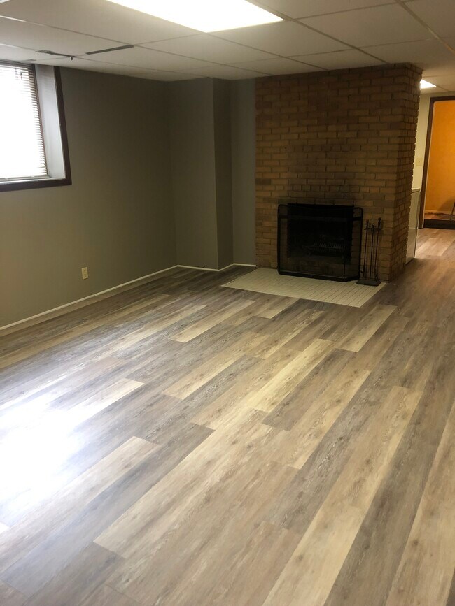 Brand new Luxury Vinyl Tile in huge greatroomand a wood fireplace - 4318 Benjamin St NE