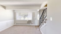 Located at 372 Kettle Creek Road in Toms River, NJ, this two-bedroom, two-bathroom two-story unit offers a practical and well-appointed layout across two floors. The main level houses the kitchen and primary living areas, while the upper level accommodates the bedrooms and additional bathroom. The kitchen is a standout feature, showcasing white shaker cabinetry, granite countertops, a mosaic tile backsplash, and light wood-look flooring. A full suite of stainless steel appliances is included—range, microwave, dishwasher, and refrigerator—alongside the added convenience of an in-unit washer and dryer. Exposed beams run throughout the ceilings, lending a distinctive architectural character to the space. Both bedrooms are carpeted and neutral-toned, with the primary bedroom offering a sliding glass door to a private balcony with outdoor views, plus a closet and wall-unit climate control. The second bedroom includes a ceiling fan and ample natural light. Each bathroom is clean and functional: one features a tub/shower combo with white tile surround, while the other includes a vanity with white cabinetry and wood-look tile flooring. A hallway and dedicated closet provide additional storage throughout.