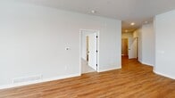 This contemporary apartment, located at 410 West Wolf River Ave in New London, offers 1120 square feet of thoughtfully designed living space. The single-story layout encompasses two bedrooms, including a spacious 170 square foot primary bedroom, and two full bathrooms. The heart of the home is an open-concept living area, seamlessly blending the kitchen and living room. The gourmet kitchen boasts light wood cabinetry, stainless steel appliances, subway tile backsplash, and a large center island with pendant lighting. High-end finishes include hardwood flooring in main living areas, plush carpeting in bedrooms, and modern ceiling fans. Large windows throughout provide ample natural light and scenic views. The bathrooms feature wood vanities and durable vinyl flooring. Additional amenities include recessed lighting, open shelving, and a neutral color palette that creates a bright, airy atmosphere. This apartment combines style and functionality, offering a perfect blend of comfort and modern urban living.