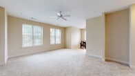 Located at 2323 Dulles Station Blvd in Herndon, Virginia, this single-floor residence offers a thoughtfully designed layout that balances comfort and functionality. The living area is generously proportioned, featuring plush neutral carpeting, warm beige walls, and multiple windows that invite abundant natural light. A ceiling fan adds both practicality and a finishing touch to the space, which flows naturally into a dedicated dining nook finished with light tile flooring and a bright window overlooking the surrounding area.

The kitchen is well-equipped for everyday use, showcasing warm honey-toned cabinetry, dark granite countertops, a classic subway tile backsplash, and a full suite of stainless steel appliances including a gas range, built-in microwave, and side-by-side refrigerator. Light tile flooring completes the clean, cohesive look.

The bedroom is carpeted and bright, with a ceiling fan and a window framing outdoor greenery. It connects to a spacious walk-in closet with wrap-around hanging rods, offering ample storage. The bathroom is finished in crisp white tile and includes both a soaking tub with shower and a separate glass-enclosed shower stall, alongside a vanity with dark countertop and direct closet access.