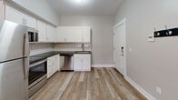 Located in Mattawan, Michigan, this efficiently designed one-bedroom, one-bathroom unit offers a thoughtful layout across a single floor. The open-concept kitchen and living area serves as the heart of the space, featuring light wood-look flooring that adds warmth throughout. The kitchen is well-appointed with crisp white shaker-style cabinetry, dark granite countertops, a white subway tile backsplash, and a full suite of stainless steel appliances including a refrigerator, electric range, over-the-range microwave, and dishwasher. A stainless steel undermount sink with a modern gooseneck faucet completes the kitchen. Natural light filters in through windows in the living area, creating a bright and welcoming atmosphere. The bedroom is carpeted for comfort and features multiple windows that allow for ample natural light, along with access to a dedicated walk-in closet outfitted with shelving. The bathroom offers a clean, contemporary design with a white vanity, dark granite countertop, and a standalone walk-in shower. Wood-look flooring continues into the bathroom, maintaining a cohesive aesthetic. In-unit washer and dryer hookups are also present, adding everyday convenience to this practical and modern living space.