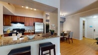 Located at 540 Carillon Pkwy in Saint Petersburg, Florida, this single-floor residence offers a well-designed, open-concept layout that balances comfort and functionality. Warm hardwood flooring flows throughout the main living areas, creating a cohesive and inviting atmosphere from entry to living room.

The kitchen is a standout feature, showcasing rich wood cabinetry, granite countertops, stainless steel appliances including a full-size refrigerator, and a peninsula with bar seating — ideal for casual dining or entertaining. The kitchen opens directly to a dedicated dining area, keeping the social spaces connected and accessible.

The living room is generously proportioned, featuring crown molding, a textured ceiling, and sliding glass doors that lead to a private outdoor balcony, filling the space with natural light. The neutral color palette throughout enhances the airy feel of the interior.

The bedrooms are carpeted for comfort and include ample natural light from large windows with blinds and curtain treatments. The primary bedroom is served by a walk-in closet with mirrored sliding doors and built-in shelving. The bathroom continues the granite and wood cabinetry theme seen in the kitchen, offering a full vanity with a large mirror and a shower/tub combination.