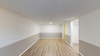 Located at 6 Lamplight Ct in London, Ohio, this single-floor, one-bedroom, one-bathroom home offers a practical and efficiently laid-out living space. The floor plan includes a living room, bedroom, kitchen, bathroom, hallway, and closet — providing all the essential areas for comfortable daily living.

The living room features light-toned luxury vinyl plank flooring and a distinctive two-tone wall treatment, with a crisp white upper half and a cool gray lower panel divided by white chair rail molding. A front-facing window allows natural light to brighten the space, complementing the textured ceiling and clean white trim throughout.

The kitchen is efficiently arranged with white cabinetry, dark countertops, a stainless steel sink, and under-cabinet lighting, offering functional prep and storage space. The layout connects smoothly to the rest of the home via a central hallway.

The bedroom is carpeted for comfort and includes a ceiling fan with light fixture, a window for natural light and ventilation, and access to a dedicated closet. The bathroom is finished in an all-white palette, featuring a tub/shower combination, a toilet, and a vanity with a dark countertop and pendant lighting — consistent with the clean, neutral aesthetic carried throughout the home.