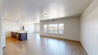 Located at 1540 E South Riverton Ave in Spokane, WA, this 2-bedroom, 3-bathroom residence offers a well-designed, single-level layout with generous living space. The open-concept living and kitchen area is a central highlight, featuring light hardwood-style flooring, a textured ceiling, and large windows with balcony views that flood the space with natural light. The kitchen is equipped with stainless steel appliances, including a range, microwave, and refrigerator, complemented by sleek gray shaker-style cabinetry and white countertops. The spacious primary bedroom is carpeted for comfort and features direct access to both a private en-suite bathroom and a walk-in closet outfitted with multi-tier wire shelving. The second bedroom is similarly appointed with carpet flooring, its own walk-in closet, and an adjacent bathroom. Two hallways connect the living areas to the private quarters, ensuring a practical flow throughout. A total of three bathrooms provide convenience for residents and guests alike. The two walk-in closets offer substantial storage with built-in wire shelving systems. Throughout the home, neutral tones and clean finishes create a bright, modern ambiance suited for comfortable everyday living.