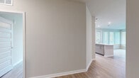 Located at 4902 Cosmos Circle in Wimauma, FL, this single-story home offers three bedrooms, two bathrooms, and three closets within a well-designed, open floor plan. Light wood-style flooring flows consistently throughout, complementing the neutral wall tones and clean white trim that define the home's modern aesthetic.

The kitchen is a standout feature, showcasing white shaker-style cabinetry, white quartz countertops, a subway tile backsplash, a central island with a dual-basin sink, and a full suite of stainless steel appliances. Abundant natural light enters through sizable windows fitted with white blinds. The adjacent living area is generously proportioned, with a ceiling fan and a bank of windows that brighten the space.

The primary bedroom is a comfortable retreat with its own ceiling fan, natural light, and direct access to an en-suite bathroom. The primary bath features a dual-sink vanity with quartz countertops, framed mirrors, a glass-enclosed shower, and wood-look tile flooring. Walk-in closets with wire shelving systems provide ample storage throughout the home.

Additional bedrooms are well-sized with ceiling fans and windows. The overall ambiance is clean, bright, and move-in ready, reflecting a contemporary design suited for comfortable everyday living.