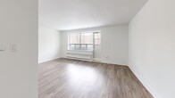 Located at 7 Elizabeth St N in Mississauga, Ontario, this 1-bedroom, 1-bathroom unit offers a thoughtfully designed layout across a single floor. The open-concept living and dining area is bright and airy, featuring wide-plank laminate flooring, crisp white walls, and large windows that flood the space with natural light while framing views of the surrounding urban streetscape. A dedicated entrance leads into a hallway with two closets, providing ample storage from the moment you arrive. The galley-style kitchen is well-equipped with white shaker cabinetry, dark granite-style countertops, stainless steel appliances, and a charcoal subway tile backsplash — a clean, modern aesthetic that balances function and style. The bedroom is a comfortable size, featuring its own window with city views, laminate flooring, and direct access to the bathroom. The full bathroom is finished with classic white subway tile surrounding a soaker tub, offering a clean and timeless look. A private balcony extends the living space outdoors, ideal for taking in the Mississauga cityscape. Overall, the unit presents a bright, neutral palette with modern finishes throughout, making it a functional and well-rounded urban residence.