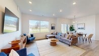 This thoughtfully designed single-floor home offers a comfortable and functional layout encompassing 2 bedrooms, 2 bathrooms, a dedicated office, and a spacious open-concept living, dining, and kitchen area. Light wood-look flooring runs throughout, complementing the clean, modern aesthetic.

The living room is generously sized, featuring large windows that frame sweeping mountain and landscape views, flooding the space with natural light. The kitchen is a standout, showcasing two-tone cabinetry — light upper cabinets paired with darker lower units — white quartz countertops, stainless steel appliances, and a central island with bar seating and pendant lighting. The adjacent dining area benefits from a sliding glass door and a stylish chandelier overhead.

The primary bedroom is a comfortable retreat with dual windows capturing outdoor views and ample natural light. It is served by a spacious walk-in closet featuring built-in shelving and hanging rods. The bathrooms are finished with light wood vanities, white countertops, and matte black hardware. A dedicated laundry room includes overhead cabinetry for additional storage. The office provides a quiet workspace with a window overlooking the exterior. The overall ambiance is bright, clean, and modern throughout.