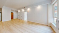 Located at 229 Willett Ave in Port Chester, NY, this thoughtfully designed one-bedroom, one-bathroom residence offers a clean, modern aesthetic across a well-utilized single floor. Light-toned hardwood flooring runs continuously throughout, creating a cohesive and airy feel in every room. The open-concept kitchen and living area serves as the heart of the home, showcasing a striking center island with a slatted wood base and white quartz countertop, complemented by a matte black faucet. White shaker-style cabinetry lines the walls alongside a marble-effect tile backsplash, and stainless steel appliances — including a French door refrigerator and slide-in range — complete the chef-ready space. Recessed and pendant lighting add both function and style. The living area is bright and open, with recessed lighting and a clean, neutral palette. The bedroom is a comfortable, well-proportioned retreat featuring a window with neighborhood views and natural light. A dedicated walk-in closet offers extensive built-in shelving and hanging rods for generous storage. The bathroom presents a spa-like finish with large-format stone-look tiles, a floating vanity with backlit mirror, matte black fixtures, and a walk-in shower.