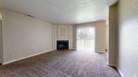 This single-story, 3-bedroom, 2-bathroom home in Shreveport, Louisiana offers a practical and comfortable layout across a well-utilized floor plan. The spacious living room serves as the heart of the home, featuring plush carpeting, a classic wood-burning fireplace with a decorative brick hearth and white-trimmed surround, and a large sliding glass door with vertical blinds that fills the room with natural light and provides outdoor access. A textured ceiling adds a traditional touch throughout the common areas. The galley-style kitchen is efficiently designed with white cabinetry, laminate countertops, a double-basin sink, wood-look flooring, and black appliances including a refrigerator, range, and dishwasher. The three bedrooms are carpeted and generously proportioned, with the primary bedroom offering notable square footage, a ceiling fan, and a window with natural light. Bedrooms include built-in shelving and closet space for convenient storage. The two bathrooms are clean and functional, with one featuring a full soaking tub, wood-look flooring, and neutral wall tones. A connecting hallway links the private sleeping quarters to the main living spaces, creating a cohesive and easy-to-navigate floor plan throughout this inviting home.
