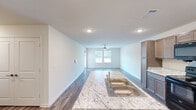 Located at 920 San Antonio Ave in Seguin, Texas, this single-story 2-bedroom, 1-bathroom home offers a clean, modern interior with a thoughtfully designed layout. Wood-look plank flooring runs throughout, lending warmth and continuity to every room.

The combined kitchen and living area serves as the heart of the home. The kitchen is well-appointed with taupe raised-panel cabinetry, light granite countertops, a peninsula with a sink, and a full suite of black appliances including a refrigerator, electric range, and over-the-range microwave. Recessed lighting illuminates the space efficiently.

The living area is open and bright, featuring neutral walls and ample room for furnishings. Both bedrooms are comfortably sized, with the primary bedroom offering a notable amount of space. Each bedroom includes window blinds that allow for natural light control, and ceiling fans provide year-round comfort. The second bedroom also features a ceiling fan and a window with an outdoor view.

The bathroom is outfitted with a walk-in shower featuring white tile surround and chrome fixtures. A dedicated walk-in closet with wire shelving provides generous storage. Throughout the home, the neutral color palette and clean finishes create a bright, move-in-ready atmosphere.