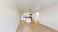 Located in Melbourne, FL, this efficiently designed one-bedroom, one-bathroom unit offers a clean, modern aesthetic across a single floor. Light hardwood-style flooring runs throughout the space, creating a cohesive and airy feel. The open-concept living, dining, and kitchen area serves as the heart of the unit, maximizing functionality. The kitchen is well-appointed with white shaker-style cabinetry, dark granite countertops, a tile backsplash, stainless steel appliances including a refrigerator, range, and microwave, and a central island that provides additional prep and storage space. A deep utility sink with a modern faucet adds a practical touch. The living area receives natural light through a large window overlooking the landscaped grounds. The bedroom is a comfortable, well-proportioned room with a ceiling fan, a natural light-filled window, and a dedicated closet with built-in shelving. The bathroom features marble-style tile flooring, white shaker vanity with granite countertop, and a fully tiled tub-shower combination with clean white subway tiles and matte black fixtures. Three closets offer ample storage throughout the unit. Outside, the property is surrounded by lush green lawns and mature palm and shade trees.