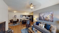 Located at 7660 S Winnipeg St in Aurora, Colorado, this single-floor residence offers a thoughtfully designed open-concept layout that seamlessly connects the living, dining, and kitchen areas. Wood-style flooring flows throughout the main living spaces, contributing to a warm, cohesive aesthetic, while a ceiling fan with a light fixture anchors the living room. Large windows fitted with horizontal blinds allow natural light to fill the space and provide views of the surrounding area.

The kitchen is a standout feature, equipped with dark espresso cabinetry, granite-style countertops, and a full suite of stainless steel appliances, including a refrigerator, range, microwave, and dishwasher. A generous island with pendant lighting provides additional prep and seating space, while a wine rack adds a refined touch. The adjacent dining area comfortably accommodates a full dining set.

The two bedrooms are carpeted for comfort, each featuring windows with natural light and ceiling fans or ample lighting. Both bathrooms mirror the kitchen's design sensibility with dark cabinetry, granite-style countertops, wood-style flooring, and full tub-shower combinations, delivering a consistent, modern finish throughout the entire residence.