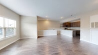 Located at 1501 SE Bison Rd in Bartlesville, Oklahoma, this one-bedroom, one-bathroom unit offers a clean, modern design across a comfortable single floor. The open-concept layout seamlessly connects the living room, dining area, and kitchen, all finished with durable wood-look flooring that lends warmth to the space. A large window in the living area lets in an abundance of natural light and offers views of the surrounding neighborhood.

The kitchen is a standout feature, equipped with rich dark-toned cabinetry, granite countertops, a classic subway tile backsplash, stainless steel appliances including a range, microwave, refrigerator, and dishwasher, plus a pantry for additional storage. A peninsula provides extra counter space and serves as a natural divider between the kitchen and living areas.

The bedroom is a comfortable retreat with plush carpeting, a ceiling fan, natural light from a window, and two closets offering generous storage. The full bathroom is finished with tile flooring, a granite-topped vanity with dark cabinetry, and a shower-tub combination. Additional conveniences include a dedicated laundry area and a hallway connecting the private spaces of the home.