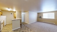 Located at 1636 S Main St in Moscow, Idaho, this single-floor, three-bedroom, two-bathroom unit offers a practical and well-organized layout across a comfortable footprint. The open living and kitchen area serves as the heart of the home, featuring tile-style flooring that transitions into plush carpeting in the living space. The kitchen is equipped with warm wood-toned cabinetry, ample counter space, a stainless steel sink, and white appliances including a refrigerator and dishwasher — providing everything needed for everyday cooking. The spacious living room receives natural light through a window and includes a wall-mounted air conditioning unit and baseboard heating for year-round comfort. The three bedrooms are carpeted and well-proportioned, each featuring windows that bring in natural light. Closet space is a highlight, with a generous walk-in closet offering dual hanging rods and shelving for abundant storage. Both bathrooms are finished with tile-style flooring and warm-toned vanities; the full bathroom includes a shower-tub combination. A dedicated laundry room with washer and dryer hookups, overhead cabinetry, and tile flooring adds exceptional convenience. The unit's neutral color palette and clean design make it a versatile and move-in-ready home.