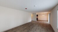This single-floor, 2-bedroom, 1-bathroom residence in Beaumont, Texas is thoughtfully designed with a clean, modern aesthetic throughout. The open living area features rich, dark wood-style plank flooring and bright white walls that create a fresh, inviting atmosphere. Natural light filters in through blinded windows, and an elegant chandelier adds a refined touch to the dining area.

The galley-style kitchen is a standout feature, boasting rich dark espresso cabinetry, granite-style countertops, black appliances including a range and refrigerator, and a stainless steel sink — all complemented by wood-style flooring that flows seamlessly from the main living areas.

Both bedrooms are carpeted for comfort and feature ceiling fans with integrated lighting. Each room includes a window with blinds that allows for natural light and ventilation. The bedrooms offer generous wall space, providing ample flexibility for furnishing arrangements.

The full bathroom is efficiently appointed with a tub-shower combination, a granite-topped vanity with dark wood cabinetry, and wood-style flooring that ties in with the rest of the home's design palette.

Overall, this residence presents a cohesive and practical layout with contemporary finishes suited for comfortable everyday living.