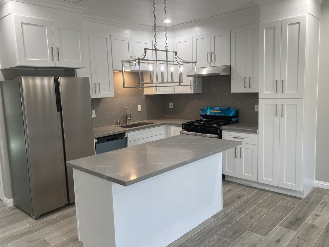 Spacious kitchen with island, quartz countertops, white shaker cabinets and stainless steel applianc - 10508 Mattock Ave