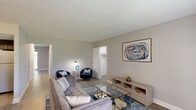 Located at 9071 Mill Creek Rd in Levittown, PA, this well-appointed one-bedroom, one-bathroom unit is set within a classic brick building surrounded by mature trees and lush greenery, offering a peaceful residential setting. The single-floor layout makes efficient use of its space, accommodating a variety of rooms including a living room, kitchen, bedroom, bathroom, office, laundry area, hallway, and four closets.

The living room is bright and welcoming, featuring light hardwood-style flooring, neutral gray walls, and a large window that fills the room with natural light. The kitchen has been updated with a two-tone cabinet design — crisp white uppers paired with dark lower cabinets — complemented by a subway tile backsplash, light stone countertops, and stainless steel appliances including a refrigerator, dishwasher, and gas range.

The generously sized primary bedroom is carpeted for comfort and includes a window with natural light, ample closet space, and a calm, neutral color palette. The bathroom is cleanly finished with gray tile flooring, a rich wood vanity with stone countertop, and a full tub-shower combination. A dedicated office adds functional flexibility to the layout. The brick exterior and green outdoor surroundings complete this comfortable and practical home.
