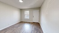 Located at 420 Lake Hill Dr in Vicksburg, Mississippi, this single-floor, one-bedroom, one-bathroom unit offers a practical and efficiently organized layout. Wood-look plank flooring runs consistently throughout the space, lending a cohesive, clean aesthetic to every room.

The living room serves as the main gathering area and features a pass-through window that connects directly to the kitchen, enhancing the sense of openness between the two spaces. A paneled white door provides front entry, with a window allowing natural light to filter in. The kitchen is outfitted with warm, honey-toned wood cabinetry, ample counter space, and a sink, making the most of the compact footprint.

The bedroom is a well-proportioned room featuring a double-door closet for storage, neutral gray walls, and continued wood-look flooring. A window brings in natural light, creating a comfortable atmosphere. Access to the bathroom and hallway is conveniently located off the bedroom.

The bathroom includes a full-size soaking tub with a shower surround, toilet, and vanity — all finished in clean white tones. A hallway connects the main rooms, ensuring a logical and easy flow throughout the unit. The textured ceilings and flush-mount lighting fixtures are consistent features across the space, contributing to its tidy, functional character.