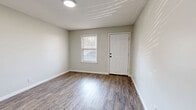 Located at 420 Lake Hill Dr in Vicksburg, Mississippi, this single-floor, one-bedroom, one-bathroom unit offers a practical and efficiently organized layout. Wood-look plank flooring runs consistently throughout the space, lending a cohesive, clean aesthetic to every room.

The living room serves as the main gathering area and features a pass-through window that connects directly to the kitchen, enhancing the sense of openness between the two spaces. A paneled white door provides front entry, with a window allowing natural light to filter in. The kitchen is outfitted with warm, honey-toned wood cabinetry, ample counter space, and a sink, making the most of the compact footprint.

The bedroom is a well-proportioned room featuring a double-door closet for storage, neutral gray walls, and continued wood-look flooring. A window brings in natural light, creating a comfortable atmosphere. Access to the bathroom and hallway is conveniently located off the bedroom.

The bathroom includes a full-size soaking tub with a shower surround, toilet, and vanity — all finished in clean white tones. A hallway connects the main rooms, ensuring a logical and easy flow throughout the unit. The textured ceilings and flush-mount lighting fixtures are consistent features across the space, contributing to its tidy, functional character.