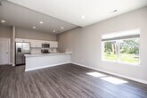 This well-designed two-story home offers 2 bedrooms and 3 bathrooms across two thoughtfully laid-out floors. The main level features an open-concept kitchen and living area bathed in natural light from large windows that frame views of the surrounding greenery. The kitchen is appointed with crisp white shaker cabinets, a white quartz peninsula with an integrated sink, and a full suite of stainless steel appliances including a refrigerator with ice maker, electric range, and microwave. Light wood-look luxury vinyl plank flooring runs throughout the main level, enhancing the bright, airy atmosphere. A convenient half bathroom with a pedestal sink is also located on the main floor. The upper level hosts both bedrooms, including a generously sized primary bedroom with a walk-in closet outfitted with multi-tier wire shelving for ample storage. Bedrooms are finished with plush carpet and ceiling fans, and each enjoys natural light through window treatments. A dedicated laundry room on the upper floor includes a full-size washer and dryer with overhead wire shelving. Three bathrooms in total serve the home, with clean, modern finishes consistent throughout. The neutral color palette and recessed lighting create a cohesive, contemporary feel across both floors.