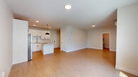 Located at 2009 Main St in Stratford, Connecticut, this single-floor unit offers a thoughtfully designed layout with a seamless blend of modern finishes and functional living spaces. Light bamboo-style hardwood flooring runs throughout, lending warmth and continuity to every room.

The open-concept kitchen and living area serves as the heart of the unit. The kitchen is well-appointed with crisp white shaker cabinetry accented by matte black hardware, a white subway tile backsplash, light quartz countertops, and a full suite of stainless steel appliances including a gas range, microwave, dishwasher, and refrigerator. A central island with pendant lighting adds both workspace and visual interest. The adjoining living area is bright and airy, benefiting from large windows that invite natural light and offer views of the surrounding neighborhood. A wall-mounted ductless mini-split system provides efficient climate control.

The bathroom features a generously sized white vanity with ample drawer and cabinet storage, a large framed mirror, stylish vanity lighting, and consistent hardwood-style flooring. A dedicated closet provides convenient storage. The overall ambiance of the unit is clean, minimal, and move-in ready, reflecting a contemporary design sensibility throughout.