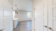 Located in Covington, KY, this thoughtfully designed single-floor residence offers a clean, modern aesthetic throughout. The open-concept layout seamlessly connects the kitchen and living areas, creating an inviting and functional flow. The kitchen is a standout feature, boasting tall light wood cabinetry, quartz countertops, a large peninsula with an undermount sink and pendant lighting, and a full suite of stainless steel appliances including a refrigerator, electric range, microwave, and dishwasher. White subway tile backsplash adds a classic touch to the contemporary design. The living area is generously proportioned with wide-plank hardwood-style flooring, a ceiling fan, and an abundance of natural light streaming through multiple windows. A glass door provides access to an outdoor balcony, offering views of the surrounding Covington landscape. The bedroom features plush carpeting, a bright window with scenic views, and ample closet space. The bathroom is finished with a wood-toned vanity, quartz countertop, large frameless mirror, and a tiled walk-in shower with glass enclosure. Neutral tones, clean lines, and quality finishes are consistent throughout, lending the space a polished and contemporary character.