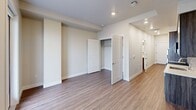 Located at 3444 South Emerson Street in Englewood, Colorado, this efficiently designed unit offers a clean, modern aesthetic throughout its single-floor layout. Warm wood-look luxury vinyl flooring runs continuously through the space, complemented by neutral, light-toned walls and crisp white trim that create a bright and cohesive atmosphere.

The open living area flows naturally toward a private balcony, accessible through a glass-paneled door alongside a large window that fills the room with natural light. The kitchen is thoughtfully appointed with dark wood cabinetry, stainless steel appliances including a refrigerator, range, microwave, and dishwasher, along with a sleek countertop and undermount sink — all contained within a compact, functional footprint.

The bedroom features recessed lighting, a dedicated closet with built-in rod storage, and direct access to the hallway leading to the bathroom. The bathroom is finished with wood-toned cabinetry, a white solid-surface countertop, an undermount sink with a modern chrome faucet, a large vanity mirror with overhead lighting, and a tiled walk-in shower. A hallway with additional storage connects the main living spaces, enhancing the overall functionality of this well-planned unit.