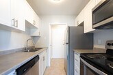 Located at 75 Mary St in Chatham-Kent, Ontario, this one-bedroom, one-bathroom unit offers a well-organized single-floor layout designed for comfortable everyday living. The open-concept living, dining, and kitchen area forms the heart of the space, bathed in natural light from large windows and a sliding glass door that leads to a private balcony with outdoor views. The kitchen is equipped with stainless steel appliances, including a full-size refrigerator, and features tile flooring that transitions seamlessly into the surrounding living areas. Throughout the main living spaces, light-toned laminate hardwood flooring adds warmth and continuity, complemented by clean white walls and neutral tones that create a bright, airy ambiance. Baseboard heating runs along the living area walls, ensuring efficient warmth throughout the unit. The bedroom is a quiet, well-proportioned room with the same laminate flooring and ample wall space, offering a restful retreat. The bathroom is finished with classic white tile surrounding a full soaker tub and shower combination, a vanity with storage, and warm beige floor tiles, delivering a clean and functional space. Overall, the unit presents a tidy, modern aesthetic with practical finishes throughout.