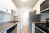 Located at 75 Mary St in Chatham-Kent, Ontario, this one-bedroom, one-bathroom unit offers a well-organized single-floor layout designed for comfortable everyday living. The open-concept living, dining, and kitchen area forms the heart of the space, bathed in natural light from large windows and a sliding glass door that leads to a private balcony with outdoor views. The kitchen is equipped with stainless steel appliances, including a full-size refrigerator, and features tile flooring that transitions seamlessly into the surrounding living areas. Throughout the main living spaces, light-toned laminate hardwood flooring adds warmth and continuity, complemented by clean white walls and neutral tones that create a bright, airy ambiance. Baseboard heating runs along the living area walls, ensuring efficient warmth throughout the unit. The bedroom is a quiet, well-proportioned room with the same laminate flooring and ample wall space, offering a restful retreat. The bathroom is finished with classic white tile surrounding a full soaker tub and shower combination, a vanity with storage, and warm beige floor tiles, delivering a clean and functional space. Overall, the unit presents a tidy, modern aesthetic with practical finishes throughout.