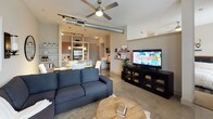 This 1-bedroom, 1-bathroom unit delivers a smartly designed single-floor layout that balances comfort and functionality. The open-concept living area features polished concrete floors, an exposed duct ceiling detail, and a ceiling fan, creating an industrial-modern aesthetic. Track lighting and pendant lights enhance the space's brightness, while built-in shelving along the walls provides both display and storage opportunities.

The kitchen is a standout feature, offering warm wood cabinetry, granite countertops, a classic tile backsplash, and a full suite of stainless steel appliances including a range, built-in microwave, dishwasher, and refrigerator. The layout maximizes counter space and storage with ample upper and lower cabinetry, making it highly practical for everyday use.

The living room provides a comfortable and inviting atmosphere, with neutral-toned walls, large windows dressed with curtains for privacy, and well-considered wall sconce lighting that adds warmth to the room.

The bathroom is clean and functional, featuring a soaking tub and shower combination with white tiling accented by a decorative mosaic border. A louvered bifold closet door adjacent to the tub adds a classic touch and provides convenient storage access. Overall, this unit presents a cohesive, modern living environment with quality finishes throughout.
