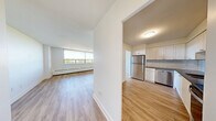This well-appointed 2-bedroom, 1-bathroom unit at 2570 Kingston Road in Toronto offers a thoughtfully designed layout across a single floor. Light hardwood flooring flows throughout the space, creating a clean and cohesive look in every room.

The living room is generously sized, highlighted by a wide bank of windows that fills the room with natural light and frames pleasant outdoor views — a standout feature of the unit. Baseboard heating runs beneath the windows, ensuring year-round comfort.

The kitchen has been tastefully updated with crisp white shaker-style cabinetry extending to the ceiling for ample storage, dark countertops, and a classic white subway tile backsplash. Stainless steel appliances, including a refrigerator, electric range, built-in microwave, and dishwasher, complete this functional and attractive space.

Both bedrooms are well-proportioned and bright. The primary bedroom offers a comfortable footprint with a sliding door closet. The second bedroom also features a sliding closet and natural light from an exterior window with outdoor views.

The bathroom is finished with full white subway tile surrounding a soaker tub and shower combination with chrome fixtures, maintaining the clean, modern aesthetic found throughout the unit. Overall, this residence offers a bright, updated, and functional living environment.