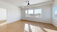 Located at 9917 NE 13th Ave in Vancouver, WA, this thoughtfully designed 2-bedroom, 1-bathroom single-floor unit offers a clean, modern aesthetic throughout. Light wood-look flooring runs continuously across all rooms, creating a cohesive and airy feel.

The open living area is bathed in natural light from a trio of large windows fitted with horizontal blinds, offering views of the surrounding neighborhood and treeline. A sleek ceiling fan with a matte black finish adds both function and style to the space.

The kitchen features warm wood-toned cabinetry paired with white countertops and a full suite of stainless steel appliances, including a refrigerator, range, microwave, and dishwasher. A stacked washer and dryer unit is conveniently integrated nearby.

Both bedrooms are bright and well-proportioned, each benefiting from natural light. The primary bedroom includes a closet and direct views to adjacent living areas, while the second bedroom features a window with outdoor views and its own closet. Clean white walls throughout lend a neutral, move-in-ready canvas.

The bathroom is finished with a wood-toned vanity, white countertop, and a full tub/shower combination with brushed nickel fixtures and grab bar. The overall design is modern, minimal, and functional.