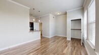 Located at 5525 Mansions Bluffs in San Antonio, TX, this efficiently designed single-floor unit makes excellent use of its compact footprint. The open living area is a standout feature, showcasing warm wood-look flooring, crown molding, and multiple windows with classic white blinds that allow abundant natural light to fill the space. The kitchen is well-appointed with dark espresso cabinetry, granite-style countertops, a breakfast bar peninsula, black appliances, and pendant lighting overhead — offering both functionality and style. A pantry provides additional storage conveniently accessible from the kitchen area. The living room is bright and airy, benefiting from multiple windows and clean, neutral-toned walls that complement the warm flooring throughout. The bathroom features a dark wood vanity with a granite-style countertop, a full soaking tub with tiled surround, and wood-look flooring that ties the space together cohesively. A dedicated laundry room accommodates a full-size washer and dryer, adding a practical touch to everyday living. A closet offers organized storage within the unit. Crown molding and consistent finishes throughout give the space a polished, cohesive aesthetic well-suited for comfortable living in San Antonio.