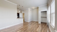 Located at 5525 Mansions Bluffs in San Antonio, TX, this efficiently designed single-floor unit makes excellent use of its compact footprint. The open living area is a standout feature, showcasing warm wood-look flooring, crown molding, and multiple windows with classic white blinds that allow abundant natural light to fill the space. The kitchen is well-appointed with dark espresso cabinetry, granite-style countertops, a breakfast bar peninsula, black appliances, and pendant lighting overhead — offering both functionality and style. A pantry provides additional storage conveniently accessible from the kitchen area. The living room is bright and airy, benefiting from multiple windows and clean, neutral-toned walls that complement the warm flooring throughout. The bathroom features a dark wood vanity with a granite-style countertop, a full soaking tub with tiled surround, and wood-look flooring that ties the space together cohesively. A dedicated laundry room accommodates a full-size washer and dryer, adding a practical touch to everyday living. A closet offers organized storage within the unit. Crown molding and consistent finishes throughout give the space a polished, cohesive aesthetic well-suited for comfortable living in San Antonio.