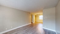 Located at 854 Sheppard Rd in Stone Mountain, GA, this single-floor, one-bedroom, one-bathroom unit offers a well-organized layout designed to maximize its compact footprint. The open-concept living and dining area is finished with durable hardwood-style flooring and neutral-toned walls, creating a bright and cohesive atmosphere. A chandelier pendant light anchors the dining area, which benefits from natural light streaming through multiple windows. The kitchen is positioned adjacent to the living space and features white cabinetry, dark granite-style countertops, a peninsula with additional storage and prep space, and black appliances including a range and refrigerator. A side door in the kitchen provides convenient exterior access. The bedroom offers a comfortable, spacious layout with plush carpeting, a window for natural light, and a textured ceiling. A dedicated closet with louvered doors provides organized storage. The bathroom is cleanly appointed with a tiled tub and shower surround featuring large-format gray tiles and modern chrome fixtures. A hallway connects the main living areas to the private spaces, contributing to an efficient and functional floor plan throughout.