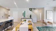 Located in Katy, TX, this two-story home offers a thoughtfully designed layout spread across two floors. The main level hosts an open-concept kitchen and living area bathed in natural light from large windows with blinds and sheer curtains. The kitchen features white shaker cabinetry, granite countertops, a subway tile backsplash, stainless steel appliances including a range, microwave, dishwasher, and refrigerator, and light wood-style flooring that flows throughout. The adjacent living room is bright and inviting, with a ceiling fan, neutral tones, and windows overlooking the exterior. A half bathroom on this floor features wood-style flooring and a window for natural light. An attached garage with an automatic opener and a window provides additional utility. Upstairs, three bedrooms each include ceiling fans and ample natural light. The primary bedroom is a comfortable retreat with multiple windows. Its walk-in closet features built-in shelving and hanging rods. The additional bedrooms are well-sized, one featuring a bold accent wall. Three full bathrooms include tub-shower combos with large-format tile surrounds, white vanities, and wood-style flooring throughout. The home's neutral palette and modern finishes create a clean, functional living environment.