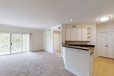 Located at 1815 Boulder Springs Dr in Maryland Heights, Missouri, this single-floor, three-bedroom, two-bathroom home offers a functional and comfortable layout. The open-concept kitchen and living area serves as the heart of the home, featuring white cabinetry, dark granite-style countertops, a built-in microwave, and a peninsula that separates the kitchen from the carpeted living room. The living room is bright and airy, highlighted by crown molding and a sliding glass door that opens to a private balcony with outdoor views. The three bedrooms are carpeted and well-lit, with the primary bedroom offering a ceiling fan and a large window that brings in generous natural light. Two hallways connect the living spaces to the bedrooms, closets, and bathrooms. The bathrooms are clean and practical, with tile flooring and a full tub-shower combination. A dedicated laundry area houses a full-size washer and dryer with overhead wire shelving for added storage. Two closets provide additional storage throughout the home. The neutral warm tones, recessed lighting, and plush carpeting throughout create a cohesive and inviting atmosphere across the entire space.