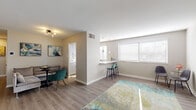 This single-floor residence offers a thoughtfully designed layout that balances comfort and functionality. The open-concept living and dining area is finished with durable wood-look flooring, neutral walls, and contemporary lighting, creating a bright and welcoming atmosphere. Large windows fitted with white blinds allow generous natural light to fill the space throughout the day.

The kitchen is a standout feature, boasting grey cabinetry, a white subway tile backsplash, stainless steel appliances, and a sleek white quartz peninsula countertop that doubles as a breakfast bar with seating for two. Pendant lighting above the bar adds a refined finishing touch.

The residence includes multiple bedrooms, each carpeted for warmth and comfort. The primary bedroom is generously sized with a walk-in closet area, while additional bedrooms feature windows that bring in natural light. The neutral color palette throughout the sleeping quarters promotes a calm, restful environment.

The bathroom is elegantly appointed with floor-to-ceiling marble-look tile surrounding the tub and shower, wood-look flooring, matte black fixtures, and a clean white vanity — offering a polished, spa-like aesthetic.

Overall, the space presents a modern, cohesive design with updated finishes and a practical, comfortable layout suited for everyday living.