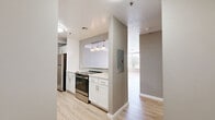 Located at 294 Main St in Hartford, Connecticut, this two-bedroom, one-bathroom residence offers a well-organized single-floor layout designed for comfortable everyday living. The open-concept living room is a standout feature, finished with light wood-style flooring and neutral gray walls that create a bright, airy atmosphere. Expansive floor-to-ceiling windows flood the space with natural light and offer views of the surrounding neighborhood. A pass-through breakfast bar connects the living area to the kitchen, which is equipped with crisp white cabinetry, a tiled backsplash, white countertops, stainless steel appliances including a refrigerator and dishwasher, and matching light wood-style flooring. Both bedrooms are carpeted and feature neutral tones, with windows that bring in natural light and offer outdoor views. The primary bedroom provides a comfortable and generously sized retreat. The bathroom is well-appointed with a tiled shower-tub combo, a white vanity with an integrated sink, a framed mirror with brushed nickel accents, and wood-style flooring that ties the space together cohesively. Throughout the residence, clean finishes and a consistent neutral palette contribute to a modern, move-in-ready aesthetic.